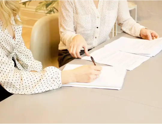 Deux personnes en train de signer des documents